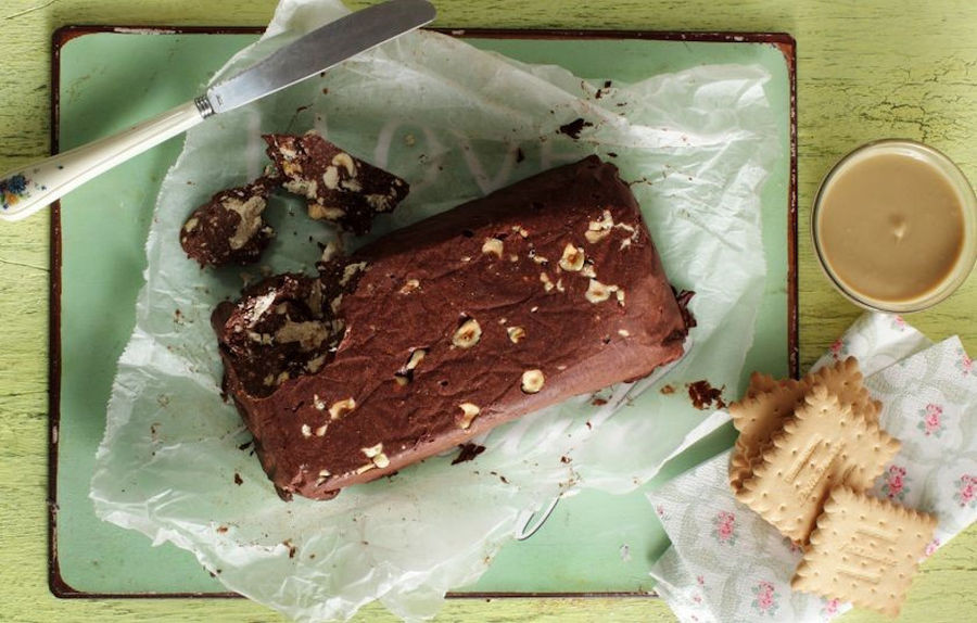 cake with biscuits and chocolate and a knife and a cup of coffee with milk from above at M. Kosmidis